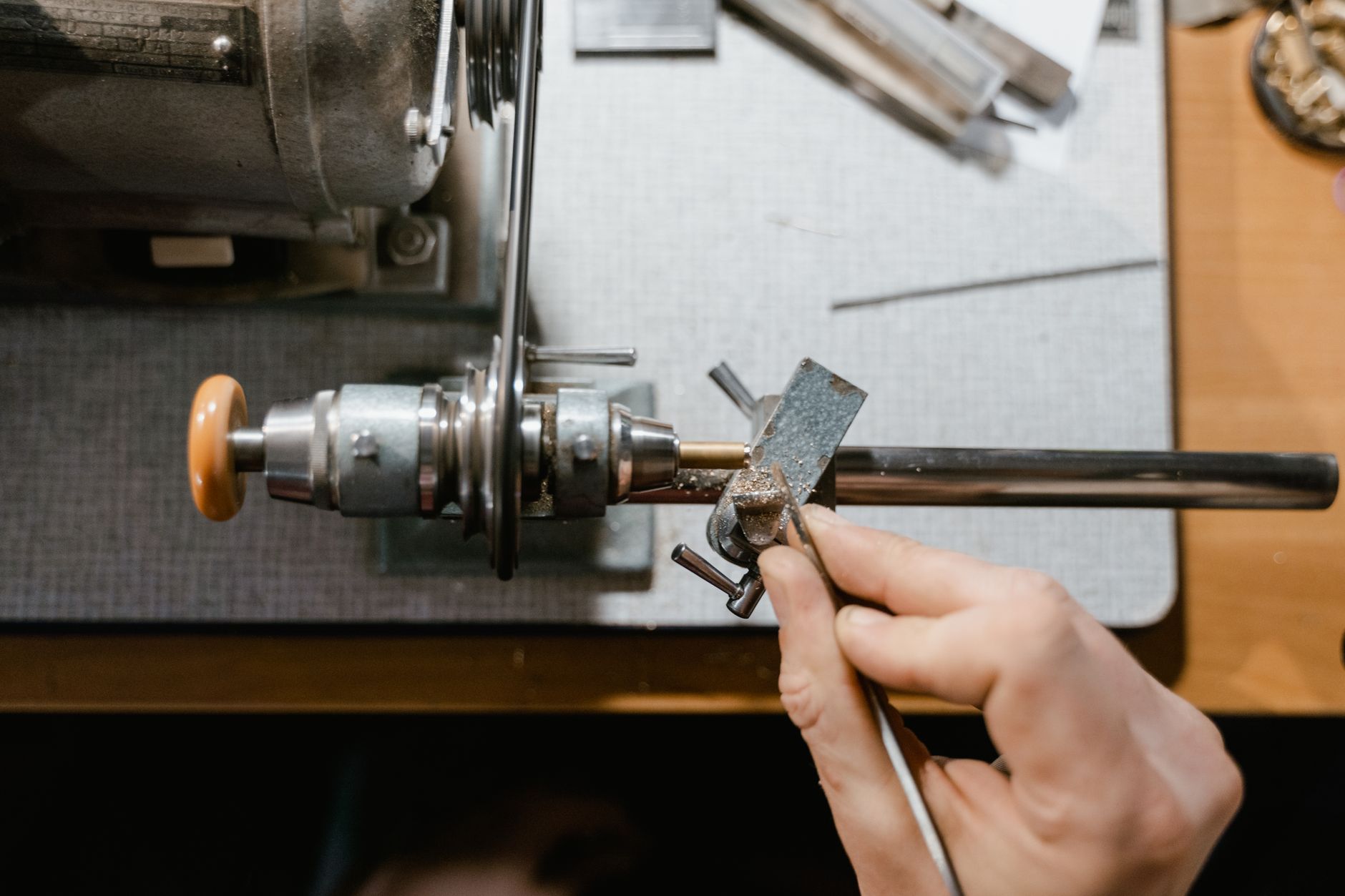 Hands using equipment at a workshop lathe